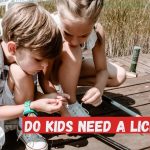 A young boy and girl tying fishing line to hook